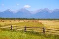 Haystacks with straw in an agricultural field. Picturesque rural landscape, mountains, blue sky. Royalty Free Stock Photo