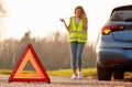 Hazard Warning Triangle Sign For Car Breakdown On Road With Woman Calling For Help 