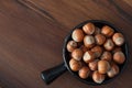 Hazel nuts in black bowl on wooden table Royalty Free Stock Photo