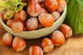 hazelnut harvest.Hazelnuts in a round green bowl with leaves close-up on a wooden table. Farmed organic ripe hazelnuts Royalty Free Stock Photo