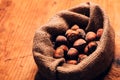Hazelnut heap in burlap sack on wooden table