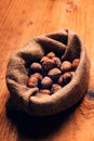 Hazelnut heap in burlap sack on wooden table