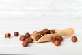 Hazelnut heap in spoon on wooden table, top view
