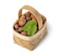 Hazelnut lies in a wooden basket on a white isolated background. Unpeeled hazelnuts in shell and green leaves Royalty Free Stock Photo