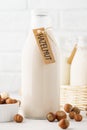 Hazelnut milk in a bottle with tag and raw ingredients