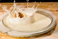 Hazelnut in milk splash. Drops on a wooden table Royalty Free Stock Photo