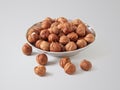 Hazelnuts in a small plate on a light background