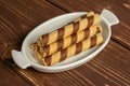 Hazelnut rolled wafer biscuit on brown wood