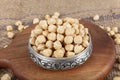 Hazelnut varieties in copper bowl on linen background. Roasted shelled hazelnuts, shelled hazelnuts and shellless roasted