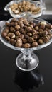 Hazelnuts and and almonds in a glass bowls on a black background with a reflection Royalty Free Stock Photo