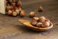 Hazelnuts in a bowl of handmade olives on a wooden board, nutshells, organic product, dark photo, place for text