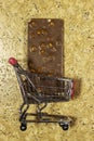 Hazelnuts chocolate bar in shopping cart on grunge background