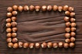 Hazelnuts create rectangular frame on wooden backdrop, rustic and textured appeal Royalty Free Stock Photo