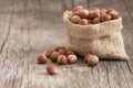 Hazelnuts, filbert in burlap sack on rustic wooden table Royalty Free Stock Photo
