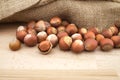 Hazelnuts beside the jute sack on wooden table Royalty Free Stock Photo