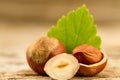 Hazelnuts with leaves on old wooden background. Royalty Free Stock Photo