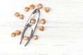 Hazelnuts and nutcracker on a white wooden background. Royalty Free Stock Photo