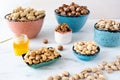 Hazelnuts peeled and in shell, cashews peeled and in shell, peeled walnuts and almonds in shell in different bowls.