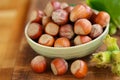 Hazelnuts in a round green bowl with green leaves. Farmed ripe hazelnuts. Nut abundance.Organic bio nuts. Healthy fats.