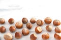 Hazelnuts in shells are scattered on the white table at the bottom of the photo. Healthy food high in antioxidants, protein