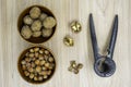 Hazelnuts and walnuts in a bowl with a few cracked with nutcracker next to it on the table. Flat lay. Royalty Free Stock Photo