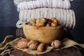 Raw walnuts and hazelnuts in bowl on desk at home and winter sweaters in background Royalty Free Stock Photo