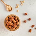 Hazelnuts in a wooden bowl, salted peanuts in a wooden spoon. The concept of healthy eating. Nuts