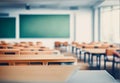 Hazy schoolroom with vacant tables and chairs and no pupils.