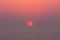 Hazy sunset on the sea with red sun