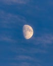 Hazy Waxing Gibbous moon surrounded by wispy clouds in a deep blue sky Royalty Free Stock Photo