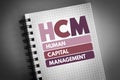 HCM - Human Capital Management acronym on notepad, business concept background