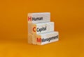 HCM, Human capital management symbol. Concept words HCM, Human capital management on wooden blocks on a beautiful orange