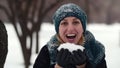 HD Happy young woman holds full plams of snow and blow it out