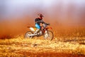 HD - Junior Motorbike kicking up trail of dust on sand track dur