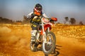 HD - Junior Motorbike kicking up trail of dust on sand track dur