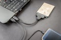 Hdd 2.5 internal hard drive disk connected to laptop and smartphone via sata usb cable closeup view Royalty Free Stock Photo