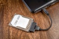 Hdd 2.5 internal hard drive disk connected to laptop via sata usb cable on wooden table closeup view Royalty Free Stock Photo