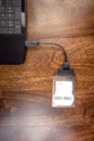 Hdd 2.5 internal hard drive disk connected to laptop via sata usb cable on wooden table closeup view Royalty Free Stock Photo