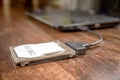 Hdd 2.5 internal hard drive disk connected to laptop via sata usb cable on wooden table closeup view Royalty Free Stock Photo