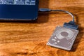 Hdd 2.5 internal hard drive disk connected to laptop via sata usb cable on wooden table closeup view Royalty Free Stock Photo