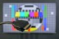 HDMI cable plug in front of tv screen displaying no signal image Royalty Free Stock Photo