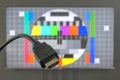 HDMI cable plug in front of tv screen displaying test image Royalty Free Stock Photo