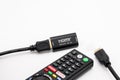 TV remote controller seen adjacent to HDMI cables and HDMI signal booster.