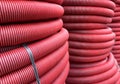 HDPE corrugated pipe texture background. Protection underground cable. Rolled up red corrugated PVC pipe. Red building pipes. Royalty Free Stock Photo