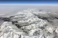 HDR Aerial photo of the landscape with clouds, snowy mountains and view stretching all the way to the horizon