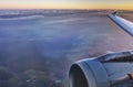 HDR Aerial photo of the landscape under a cloud cover and a horizon, with an airplane wing and engine at sunset Royalty Free Stock Photo