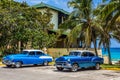 HDR - American blue classic cars with white roof parked on the beach under palms in Varadero Cuba - Serie Cuba Royalty Free Stock Photo