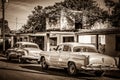 HDR - American classic cars parked before a house on the street in Santa Clara Cuba - Retro SEP