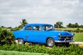 HDR Blue vintage car parked on the parking lot in Havana Cuba