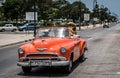 HDR Cuba orange american Oldtimer drives on the promenade Malecon in Havana